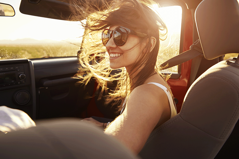 junge Frau im Auto mit Sonnenbrille